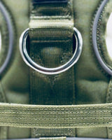 Close-up of a green tactical pouch with a metal D-ring.