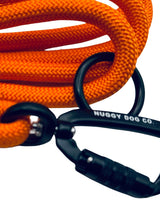 Close-up of orange dog leash with black carabiner and Nuggy Dog Co. branding on a white background