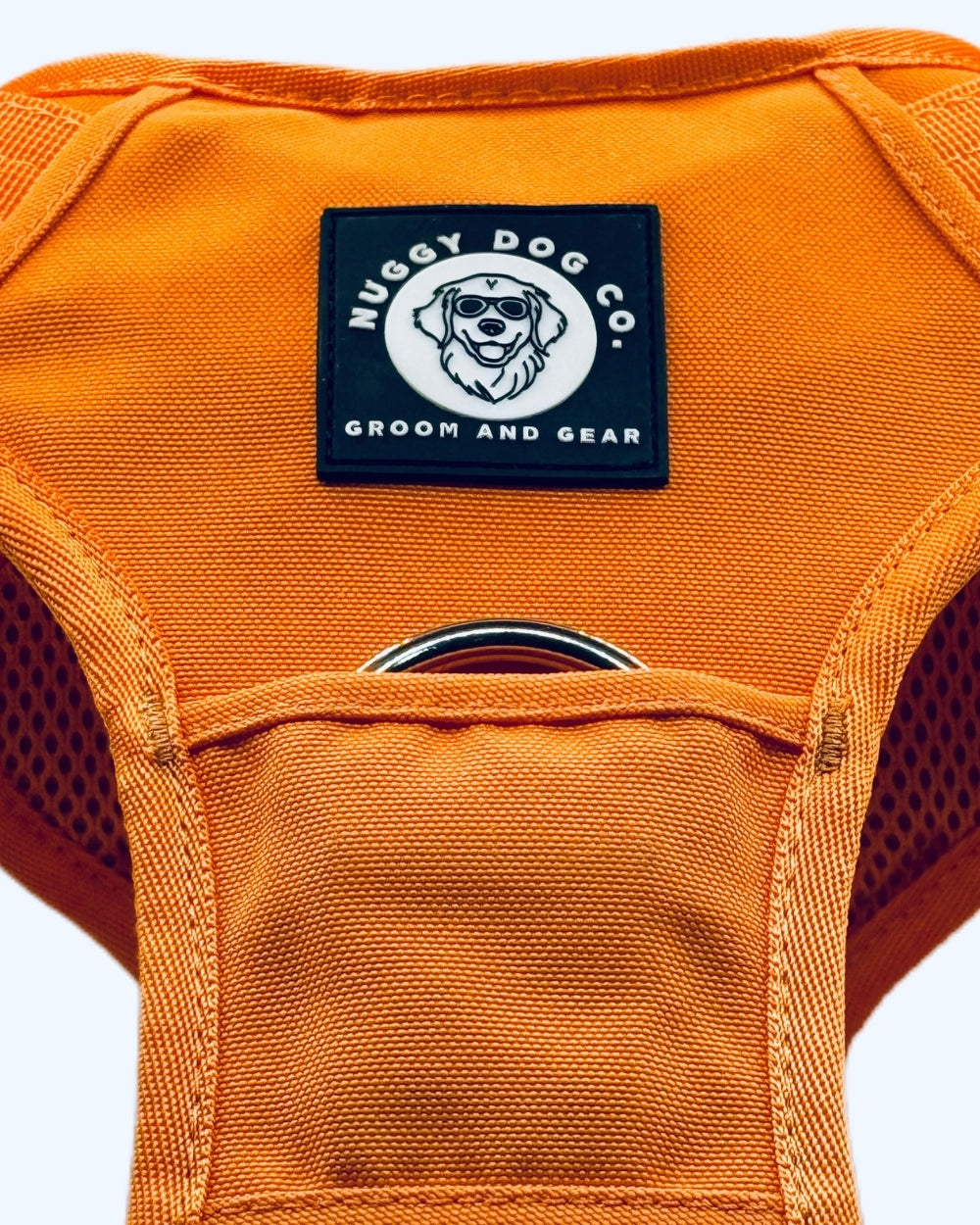 Orange dog harness with Nuggy Dog Co. label on a white background