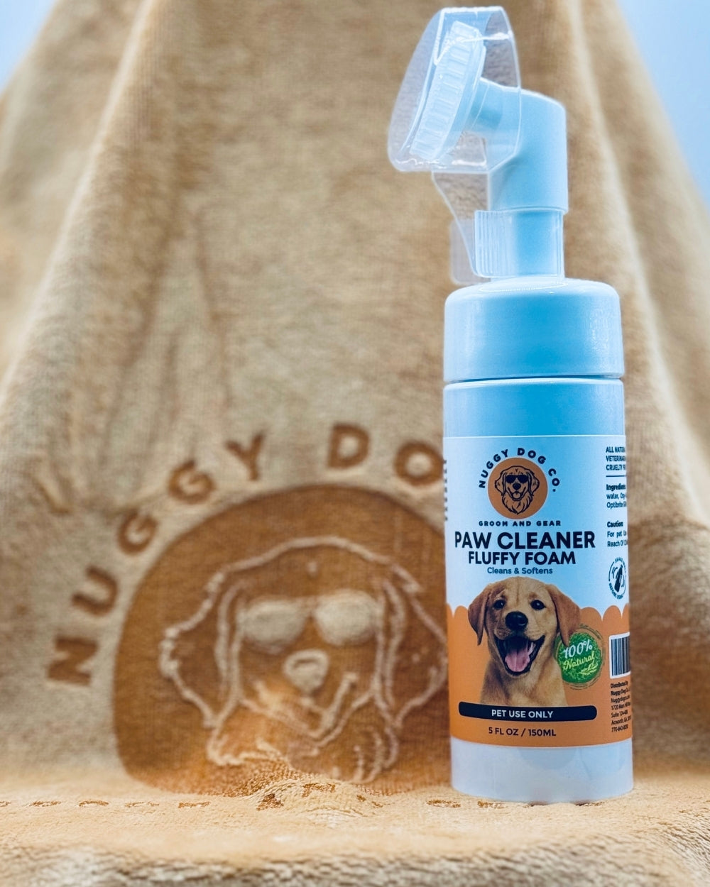 Nuggy Dog Co paw cleaner foam bottle with a towel in the background
