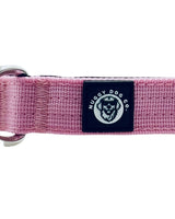 Pink dog collar with a black label featuring a logo and text on a white background